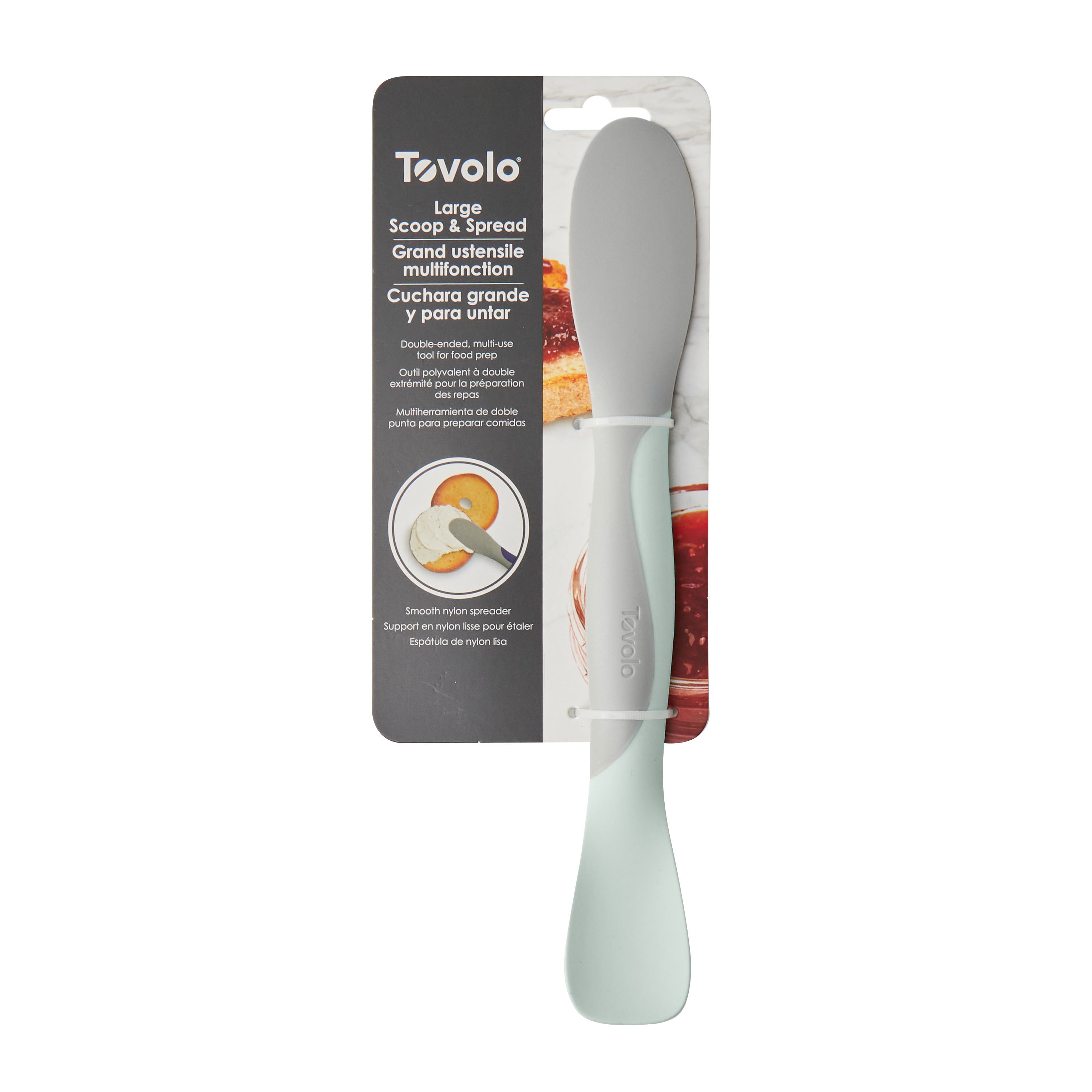 The Tovolo Scoop and Spread features a flexible light gray spatula blade and a mint green handle, packaged with info in English, French, and Spanish—a versatile kitchen tool perfect for any baker.