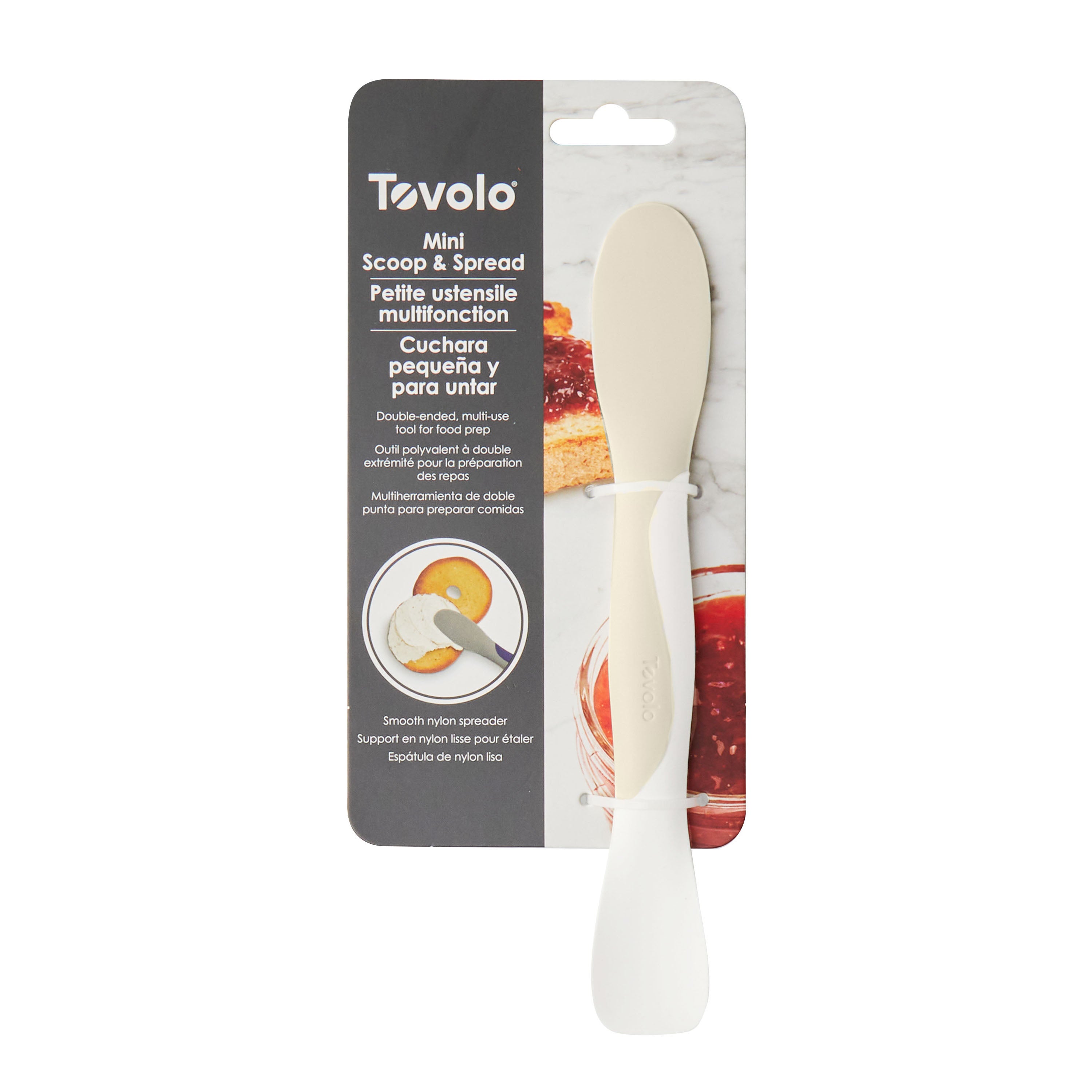 A Scoop and Spread kitchen tool in packaging, with a white spatula featuring rounded and pointed ends, shown on a gray and black background with product details in English and Spanish.