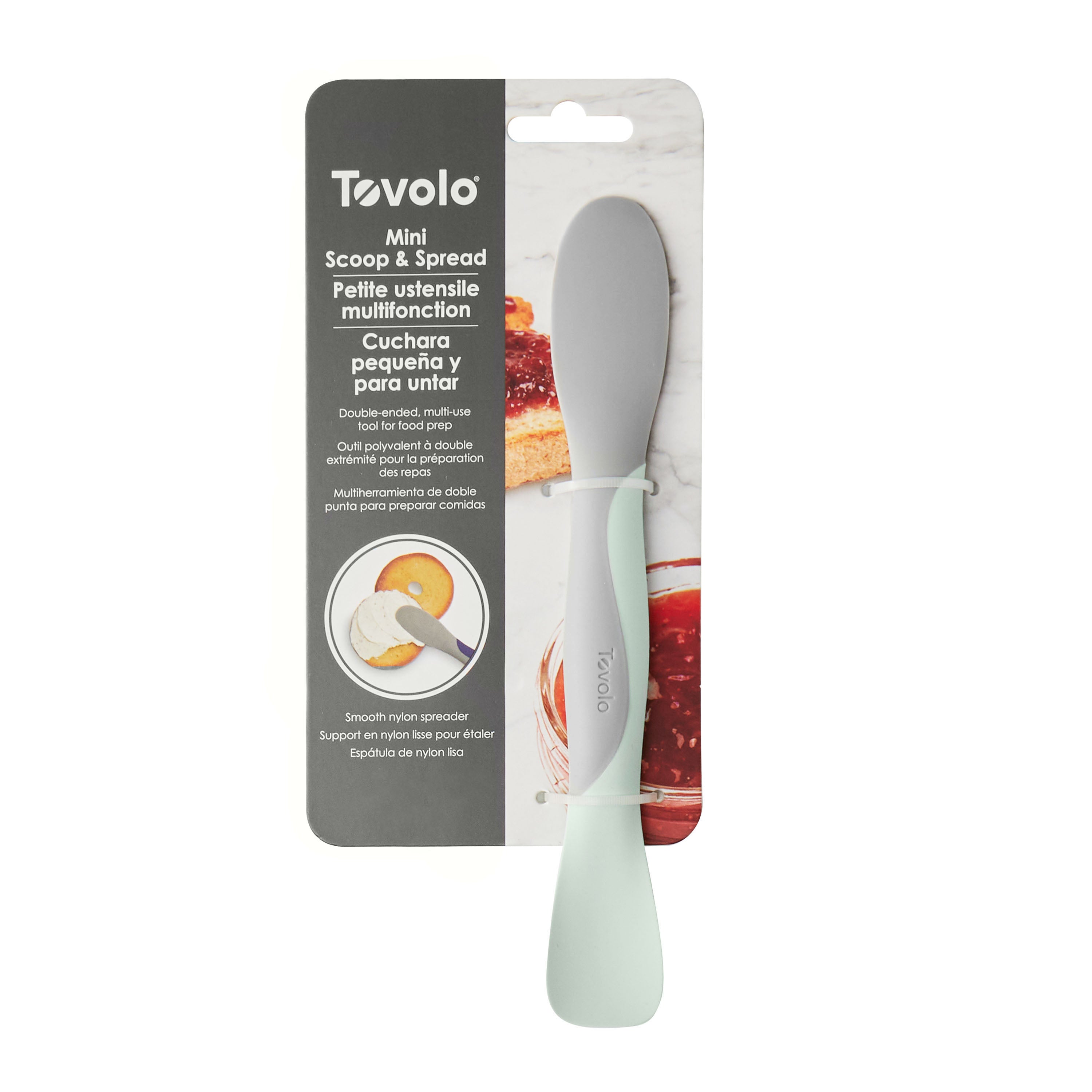 A Scoop and Spread kitchen tool in mint green and gray is shown in packaging, highlighting its dual-sided design for scooping and spreading, with product info provided in English, French, and Spanish.