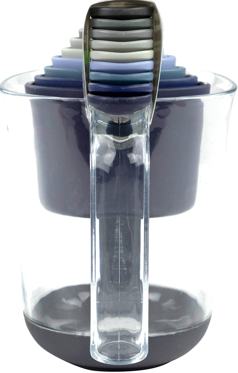 The Magnetic Nested Measuring System includes a clear plastic jug that neatly holds a set of colorful, magnetic measuring cups and etched measuring spoons in various sizes, all stacked together for easy storage.