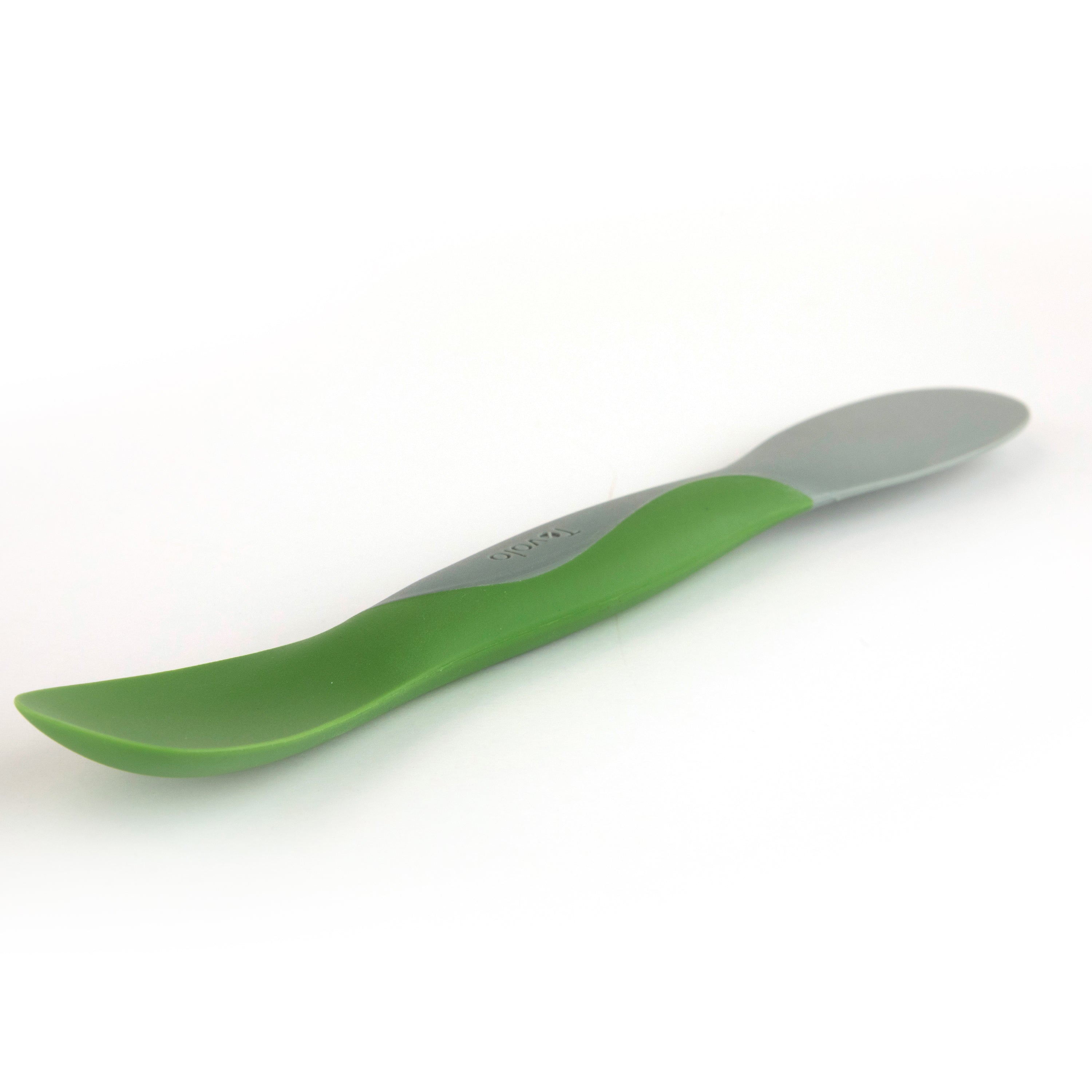 The Scoop and Spread is a gray and green plastic spoon with a curved handle, ideal for scooping and spreading your favorite ingredients, ready for use on any kitchen surface.