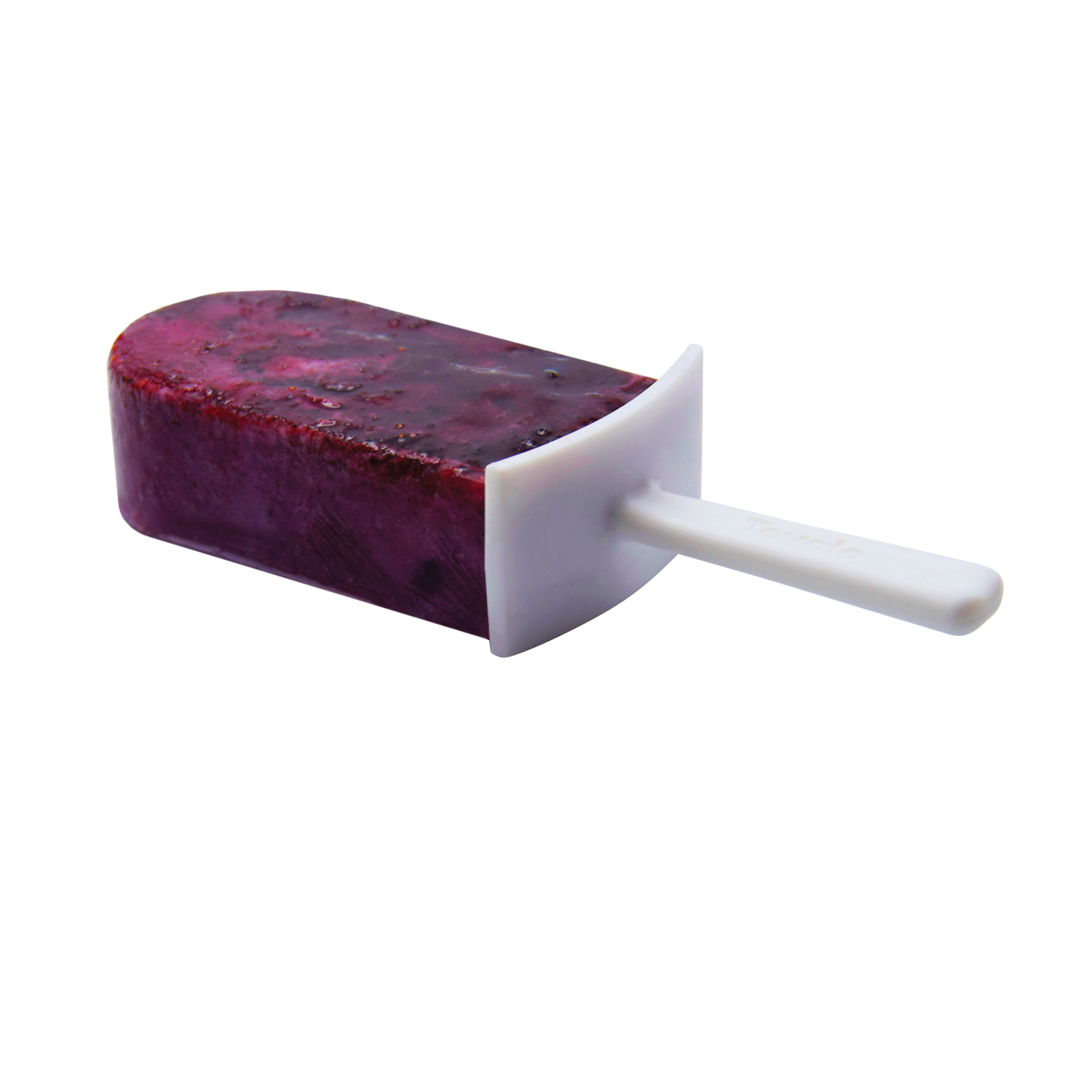 A purple popsicle with visible fruit pieces, made using the Pop Molds Stackable silicone popsicle maker, sits on a white stick against a white background.