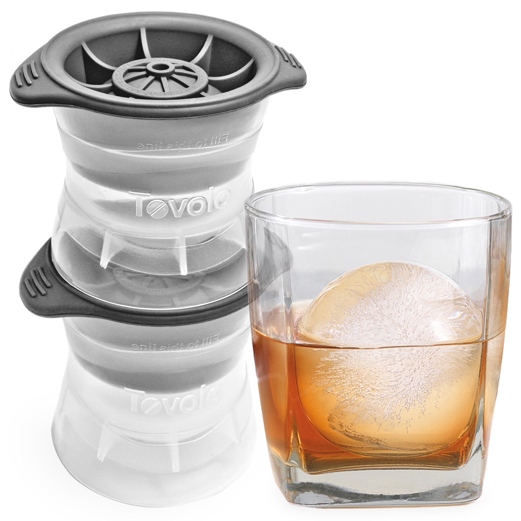 Two Ice Molds sit beside a whiskey glass holding a large, clear sphere made by the molds. The perfectly round, slow-melting Ice Molds are designed to chill drinks without watering them down too quickly.