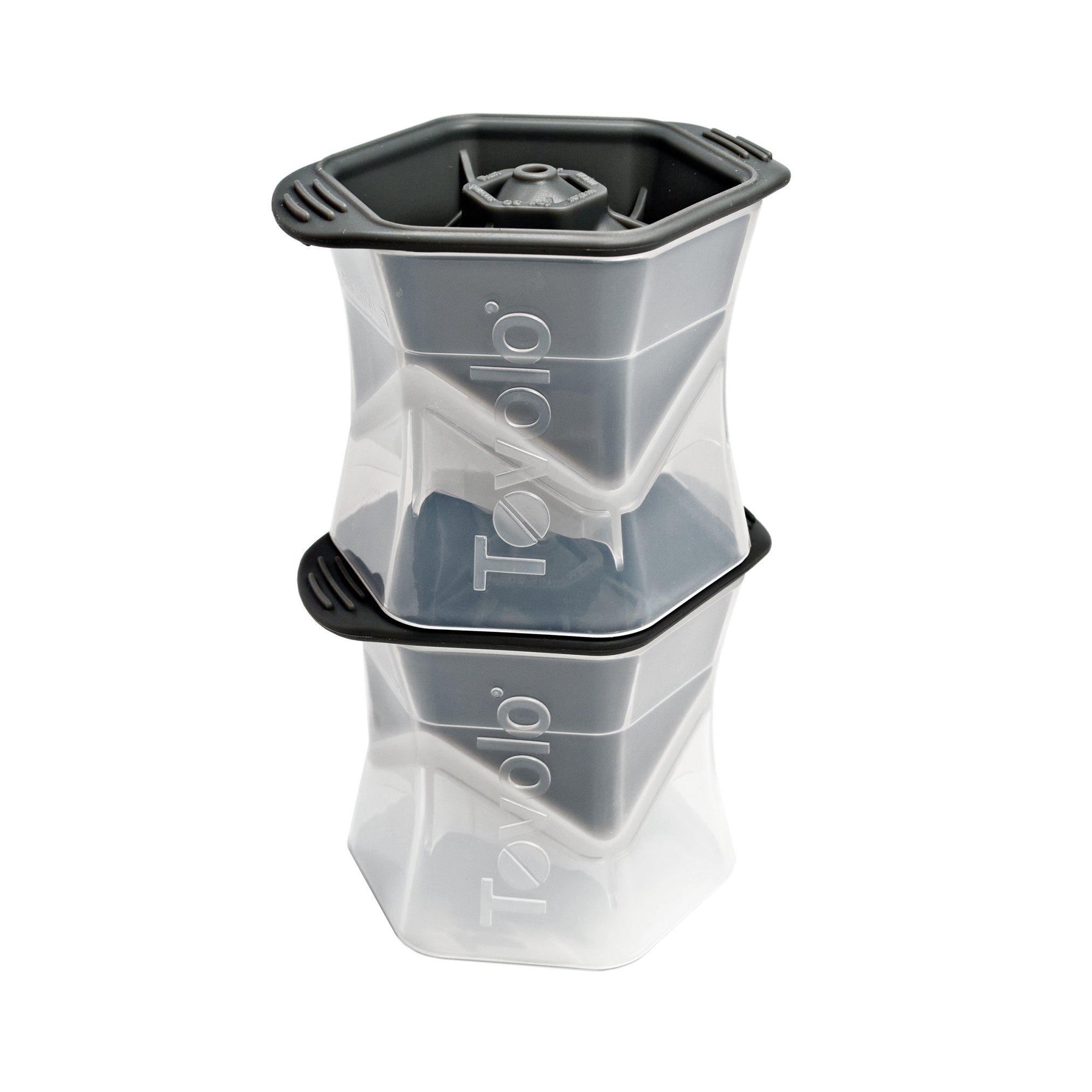 Two clear and gray Tovolo Ice Molds with black lids are stacked on a white background. Each silicone mold features a geometric design that creates slow-melting ice cubes.