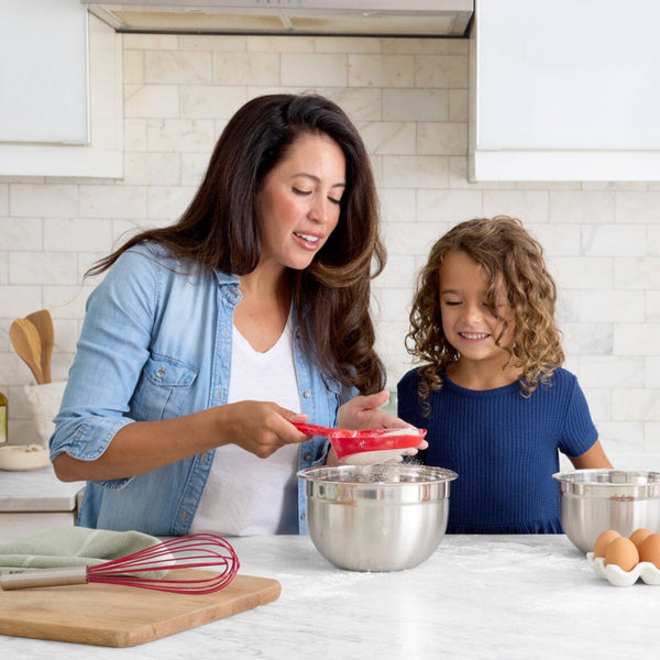 Woman and child in a kitchen preparing food together.