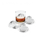 A glass of whiskey with a large, faceted heart-shaped ice cube made using tovolo’s Heart and Diamond Ice Molds (Set of 4), accompanied by three similar cubes on a white surface.