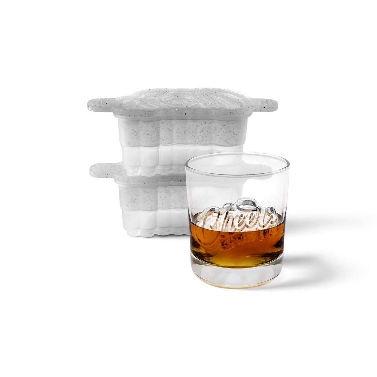 A glass of whiskey labeled "Cheers" sits before two stacked tovolo Cheers Ice Molds (Set of 2), speckled silicone trays with lids crafted to make spherical ice cubes, ideal for fans of craft ice in their drinks.