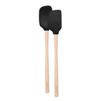 The Flex-Core Mini Spat + Spoonula features two heat-resistant utensils with black silicone heads and light wooden handles, positioned side by side on a white background—ideal for use as a mini spatula or spoonula.