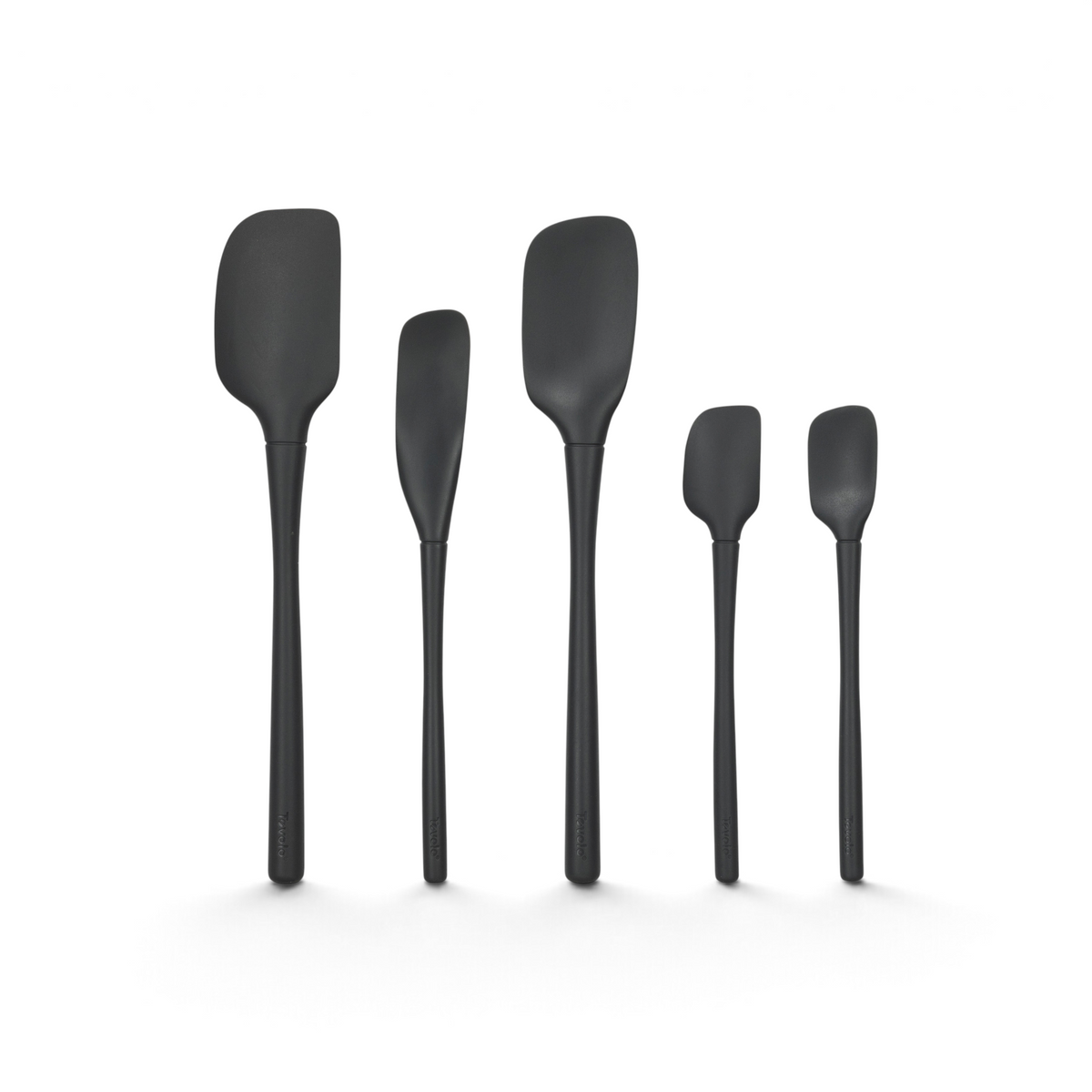 Five black Flex-Core All-Silicone Spatulas, in a set of 5, stand upright in a row on a white background, arranged from largest to smallest.