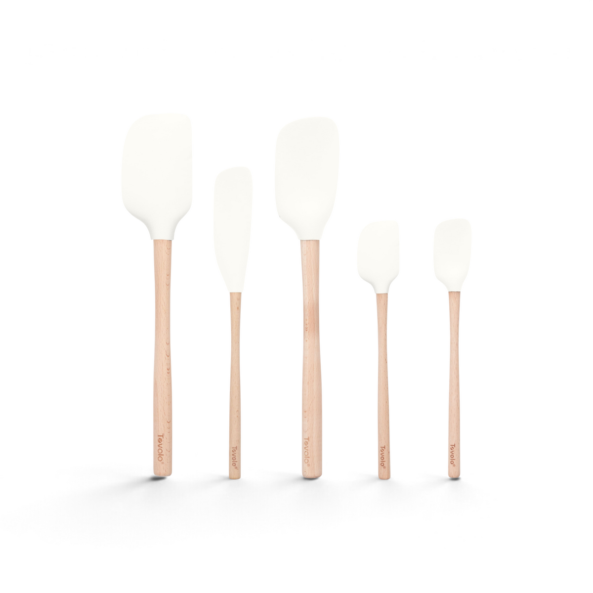 Five white Flex-Core Wood-Handle Spatulas by Tovolo, each a different size, stand upright in a row on a white background. The wooden handles feature Tovolo branding near the bottom.