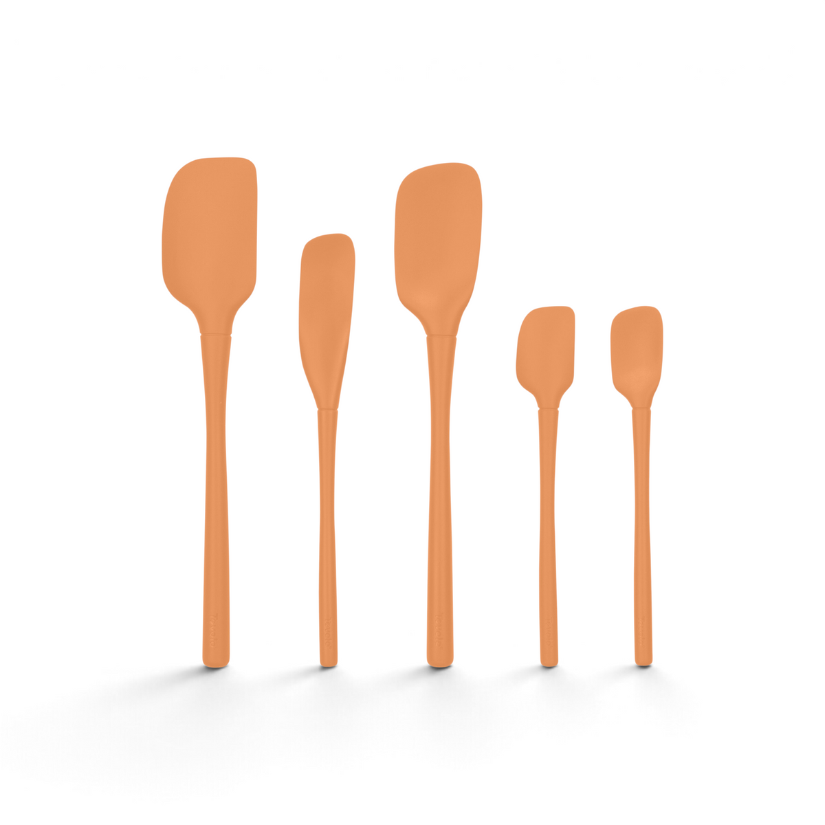 The Flex-Core All-Silicone Spatula Set of 5, in orange, features assorted sizes and shapes including a Jar Scraper, all displayed upright in a row against a white background.