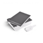 The tovolo Twist and Release Mini Ice Set includes a white rectangular storage bin, two stacked gray trays with triangular grids, and a white plastic scoop.