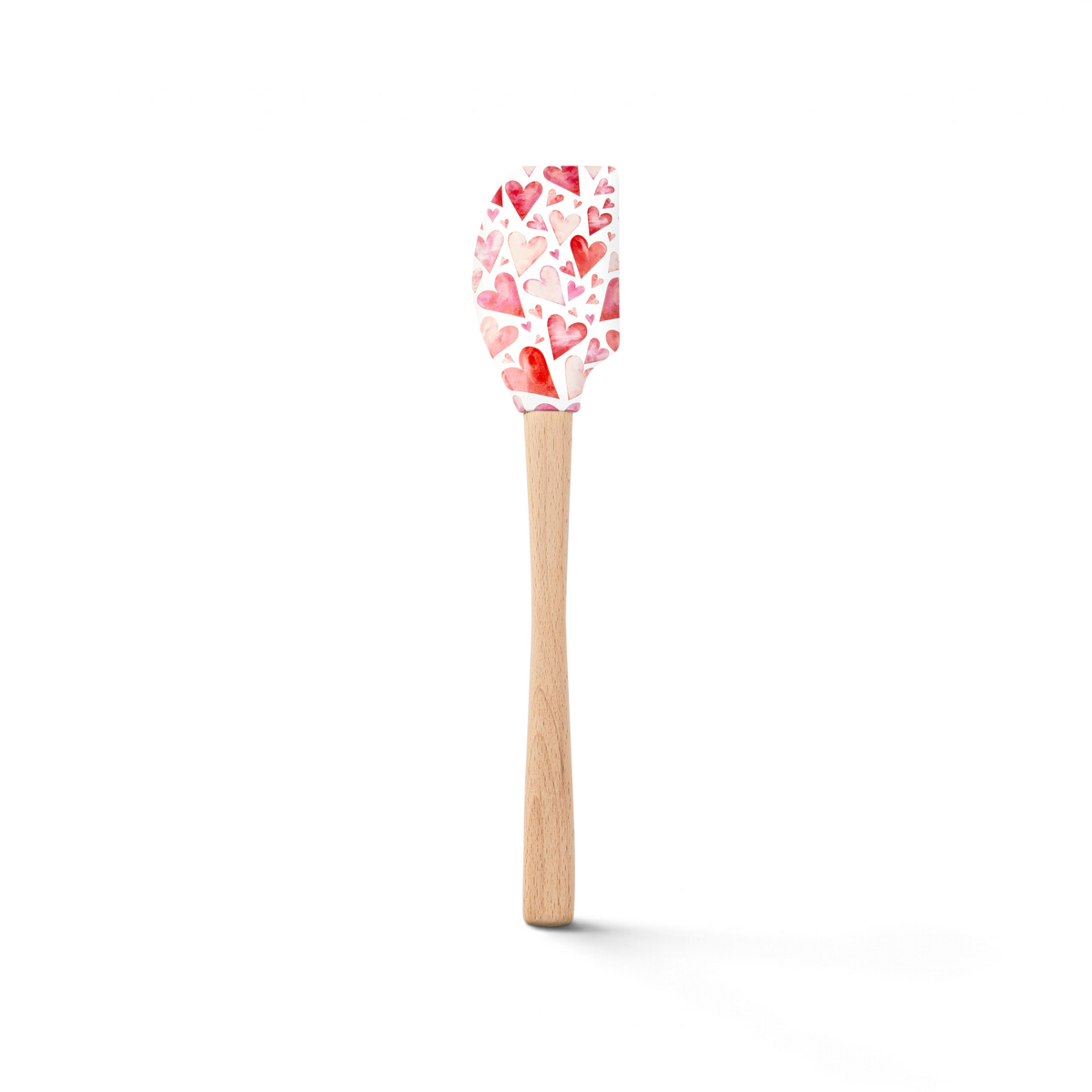 The Spring Spatulart is a wood-handled spatula with a silicone head featuring red and pink watercolor hearts on white, blending style and function for your kitchen.