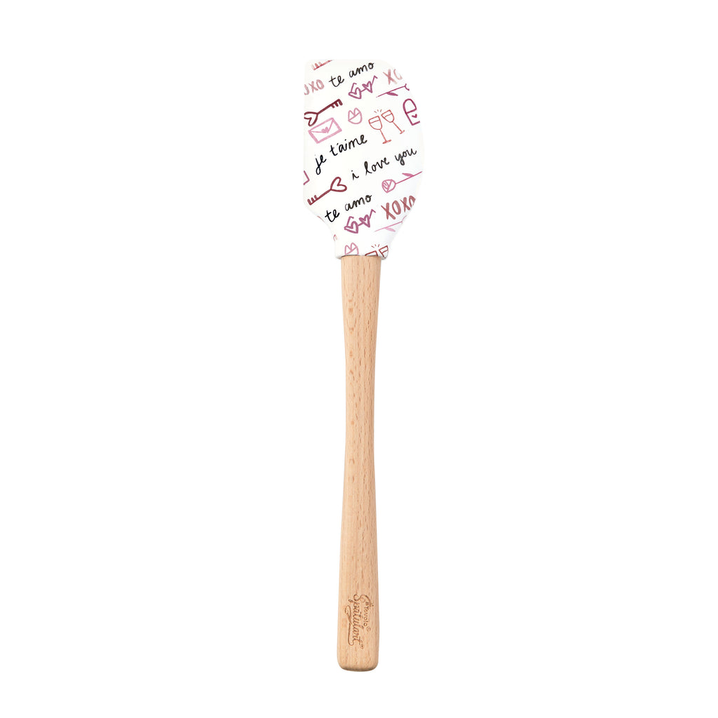 The Spring Spatulart features a wood handle and a white silicone head decorated with red and black handwritten "I love you," "te amo," hearts, and XOXO—perfect for adding a touch of love to your baking.