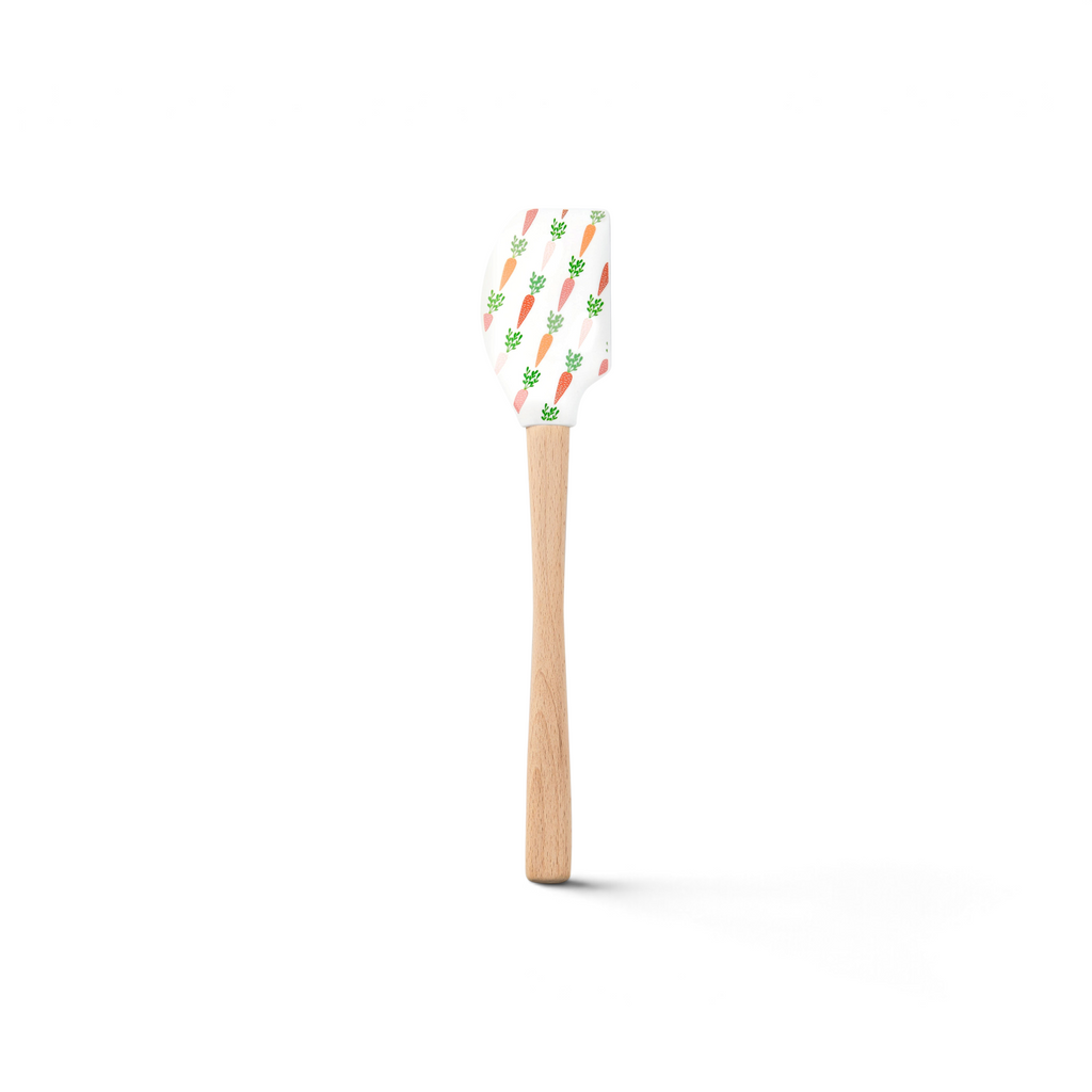 The Spring Spatulart is a wood handled spatula with a white silicone head, featuring an adorable carrot patch design with orange carrots and green tops.