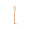 The Spring Spatulart is a wood-handled silicone spatula featuring a carrot patch design, with orange and yellow tulips and green leaves on the spatula head.