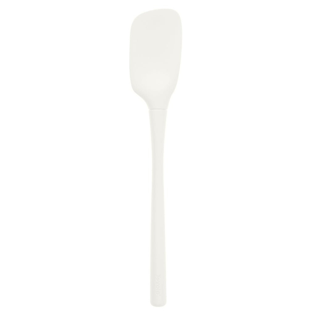 The Flex-Core Spoonula is an ergonomic silicone spatula with a long handle and a slightly curved, rectangular white blade, shown on a plain white background.