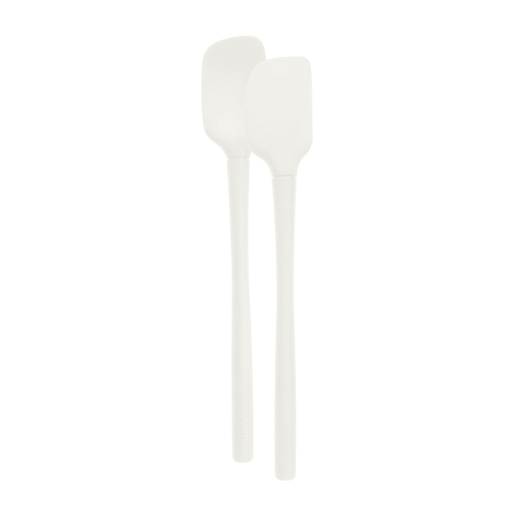 The Flex-Core Mini Spat + Spoonula, two white heat-resistant kitchen utensils with long handles, are displayed side by side on a plain white background.