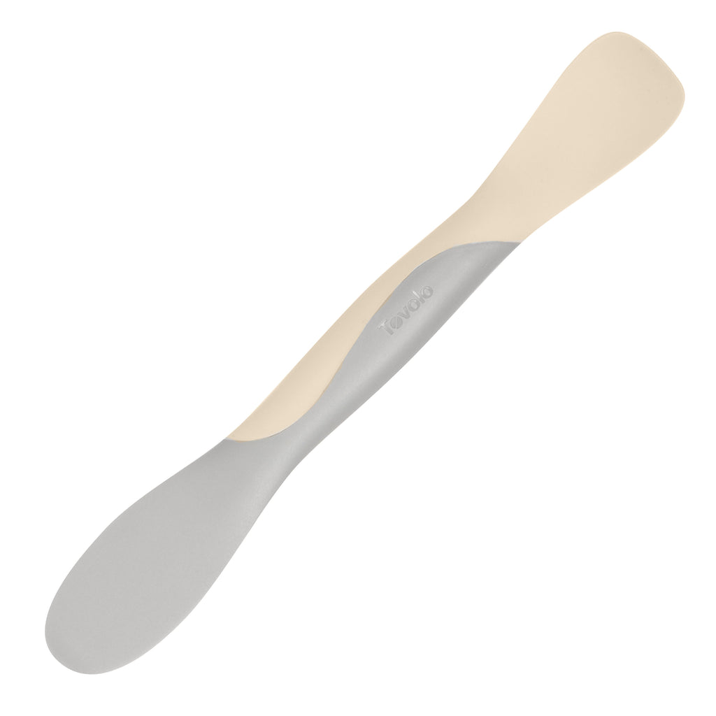 The Scoop and Spread is a versatile kitchen tool with dual ends—one flat, one rounded—for scooping and spreading. Its light grey and cream two-toned design makes it essential for every baker.