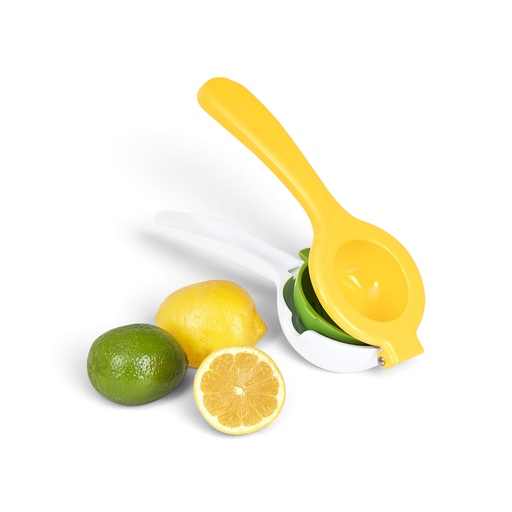 The Squeeze and Pour Citrus Press in yellow and white, featuring a removable seed strainer, is shown beside a whole lime, whole lemon, and a halved lemon with its interior visible.
