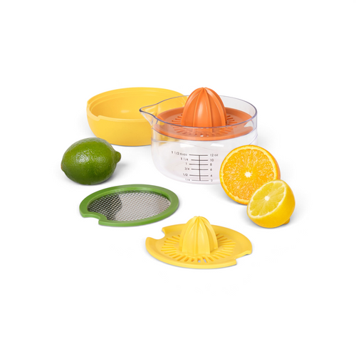 The All-in-One Juicer set, featuring multiple attachments, a measuring cup, zester, lime, half an orange, and half a lemon, is displayed on a white background.
