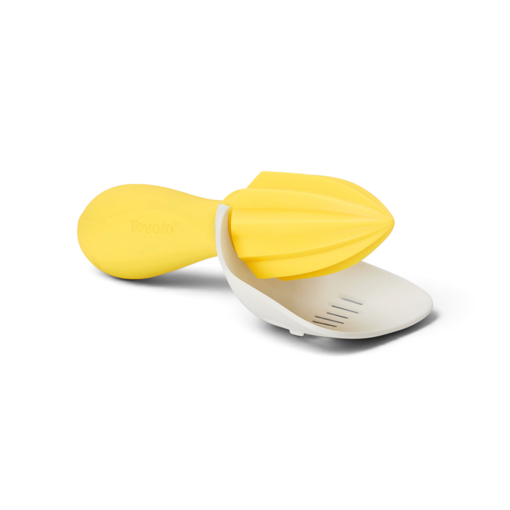 The Citrus Reamer is a yellow and white handheld juicer with a ridged reamer and curved strainer, designed for efficient juice extraction from lemons or limes.