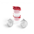 Two tovolo Santa and Reindeer Ornament Ice Molds (Set of 2), white and spherical with raised festive designs, are shown in front of two stacked clear plastic containers with red lids.