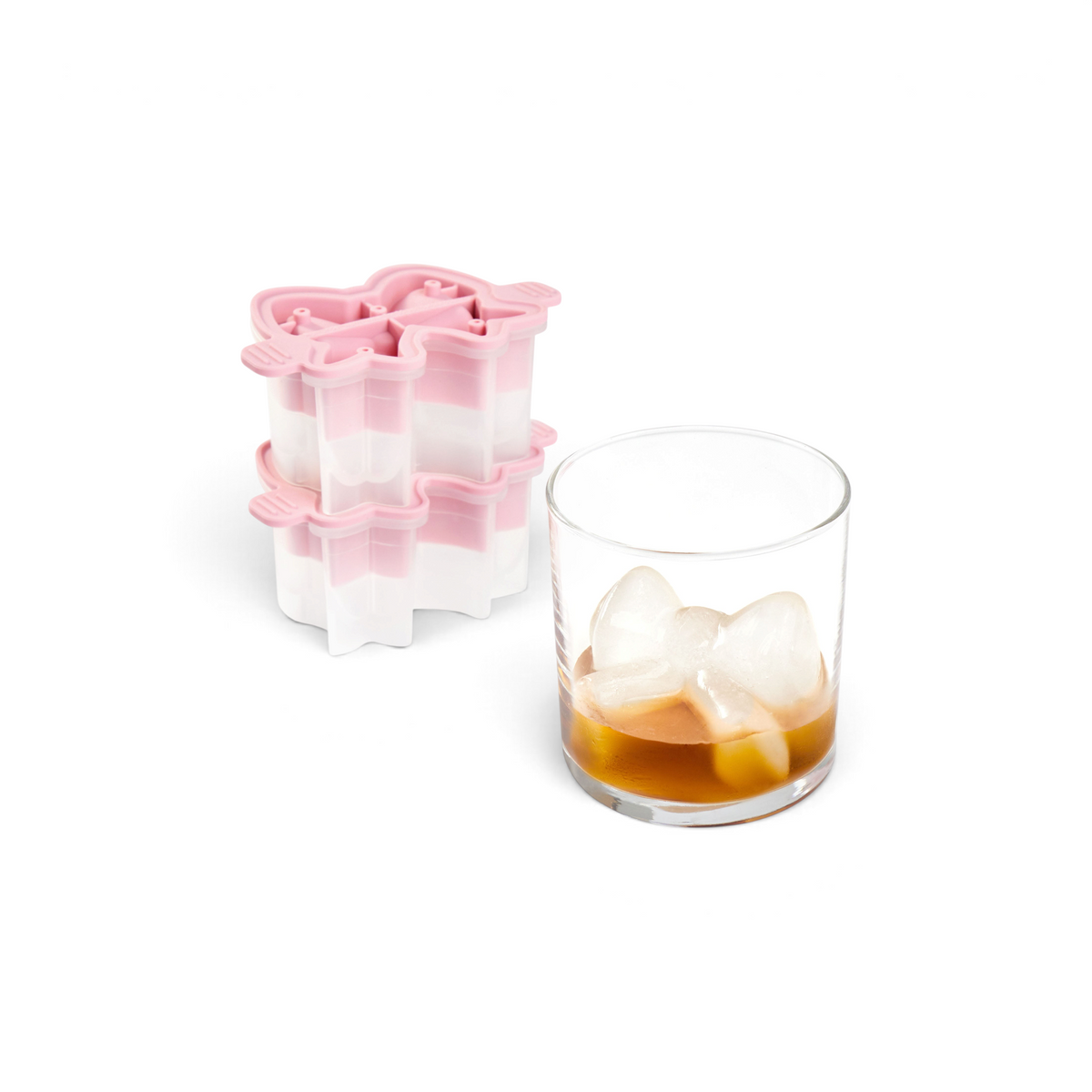 A glass with brown liquid and butterfly-shaped ice from the tovolo Fancy Bow Ice Molds (Set of 2) sits beside the pink and white silicone tray.