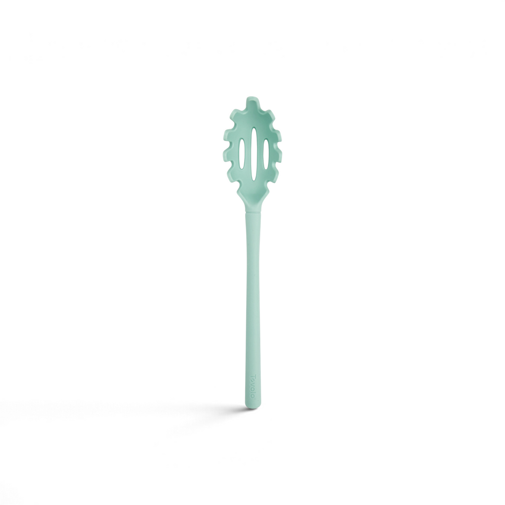 The tovolo Flex-Core Silicone Pasta Claw is a light blue server with a long handle and a slotted, forked spoon end, ideal for serving spaghetti and other long noodles.
