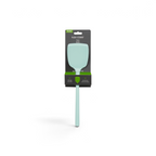A tovolo Flex-Core Silicone Solid Turner in light green is shown in its packaging, which features a wide flexible head, long handle, and black packaging with green accents and white text.
