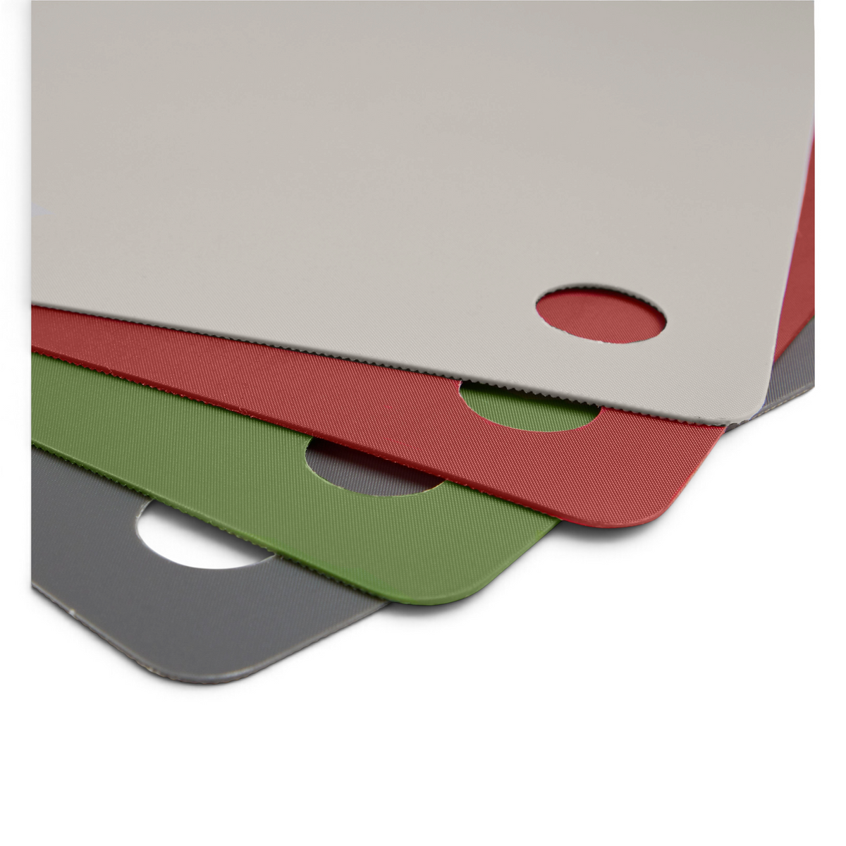 Flexible Cutting Mats in gray, green, red, and beige are stacked with rounded corners and matching holes, providing non-slip protection for kitchen countertops in a convenient layered set.