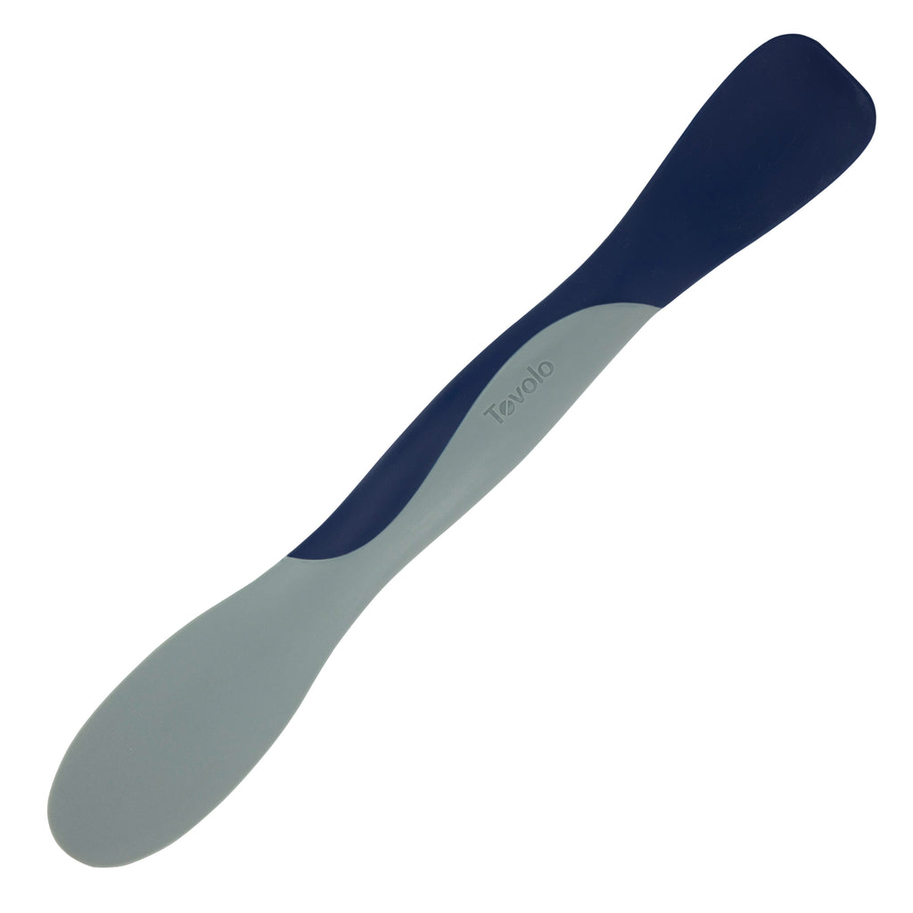 The Scoop and Spread is a dual-ended silicone spatula with Tovolo branding, featuring one gray and one navy blue end—making it an essential kitchen tool for bakers to scoop and spread effortlessly.