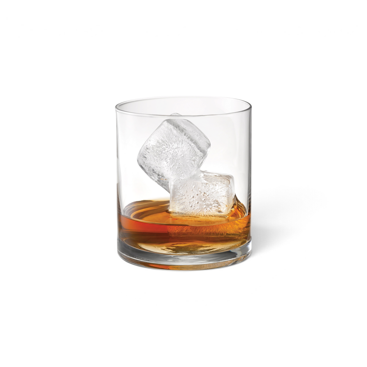 A glass of whiskey with two large, slow-melting cubes made using tovolo Double Rocks Ice Molds (Set of 2) rests on a white background.