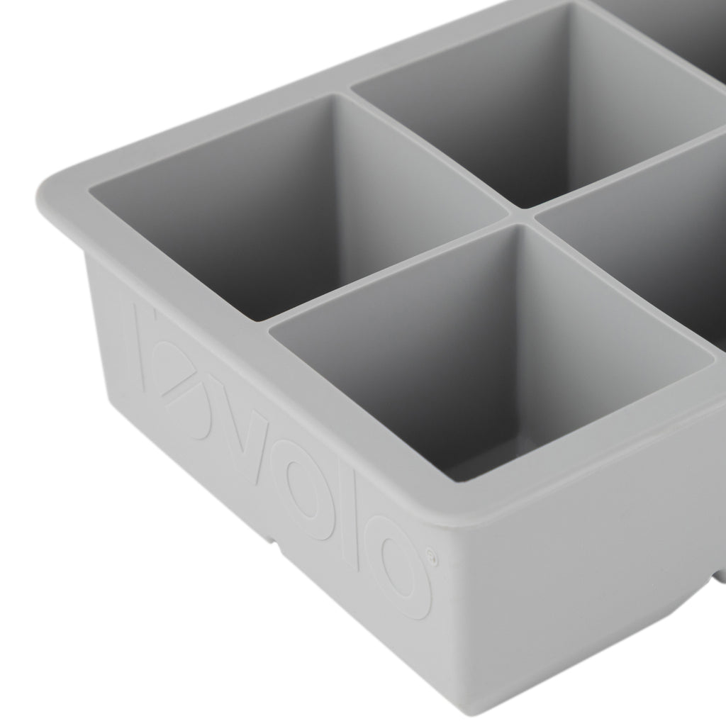 Close-up of a gray tovolo King Cube Silicone Ice Mold with four large square compartments, ideal for making craft ice, and featuring the brand name embossed on the side.