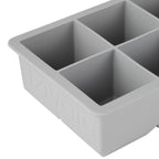 Close-up of a gray tovolo King Cube Silicone Ice Mold with four large square compartments, ideal for making craft ice, and featuring the brand name embossed on the side.