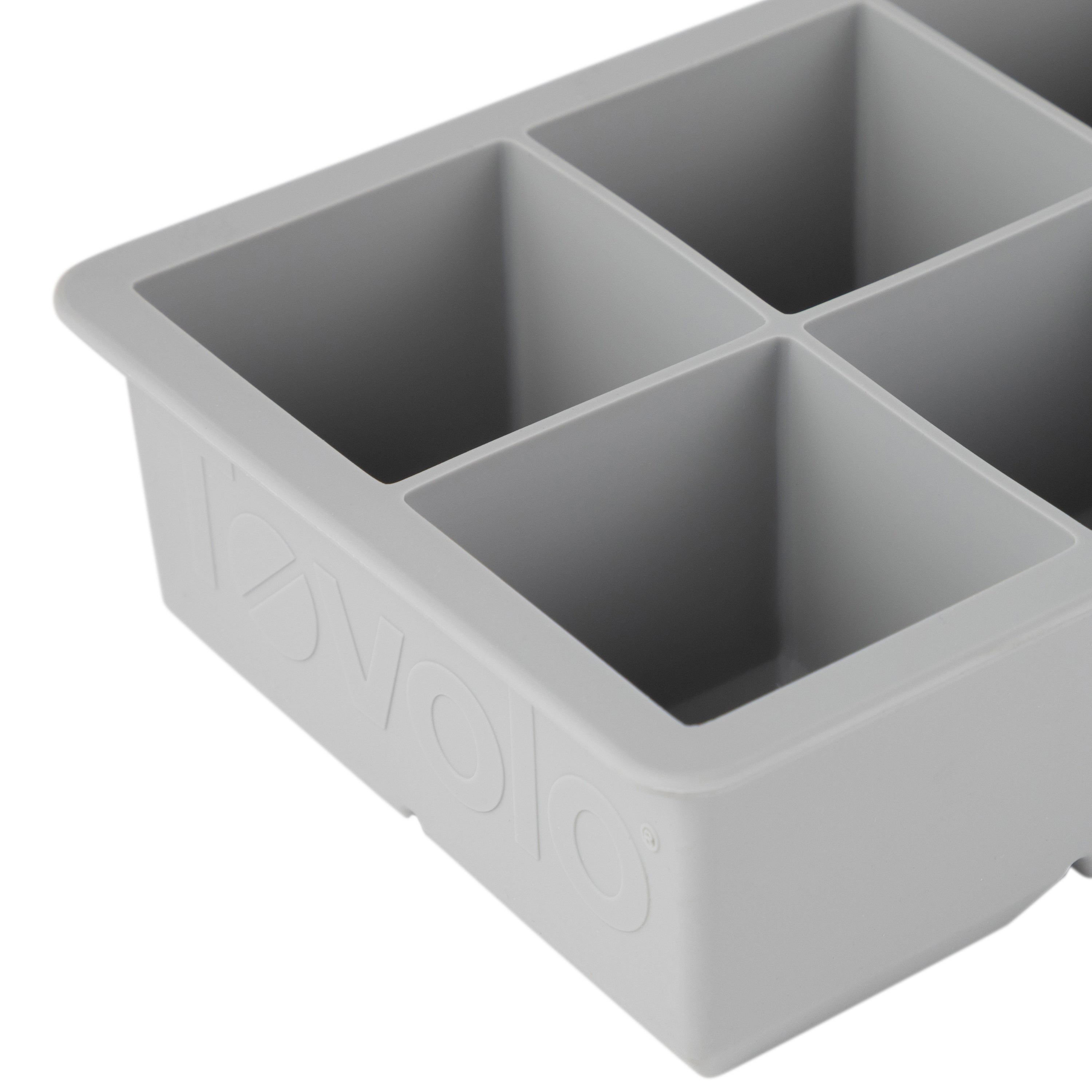 Close-up of a gray tovolo King Cube Silicone Ice Mold with four large square compartments, ideal for making craft ice, and featuring the brand name embossed on the side.