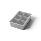 The tovolo King Cube Silicone Ice Mold features six large rectangular compartments, ideal for craft ice. This gray tray is made of silicone and has the tovolo brand embossed on the side.