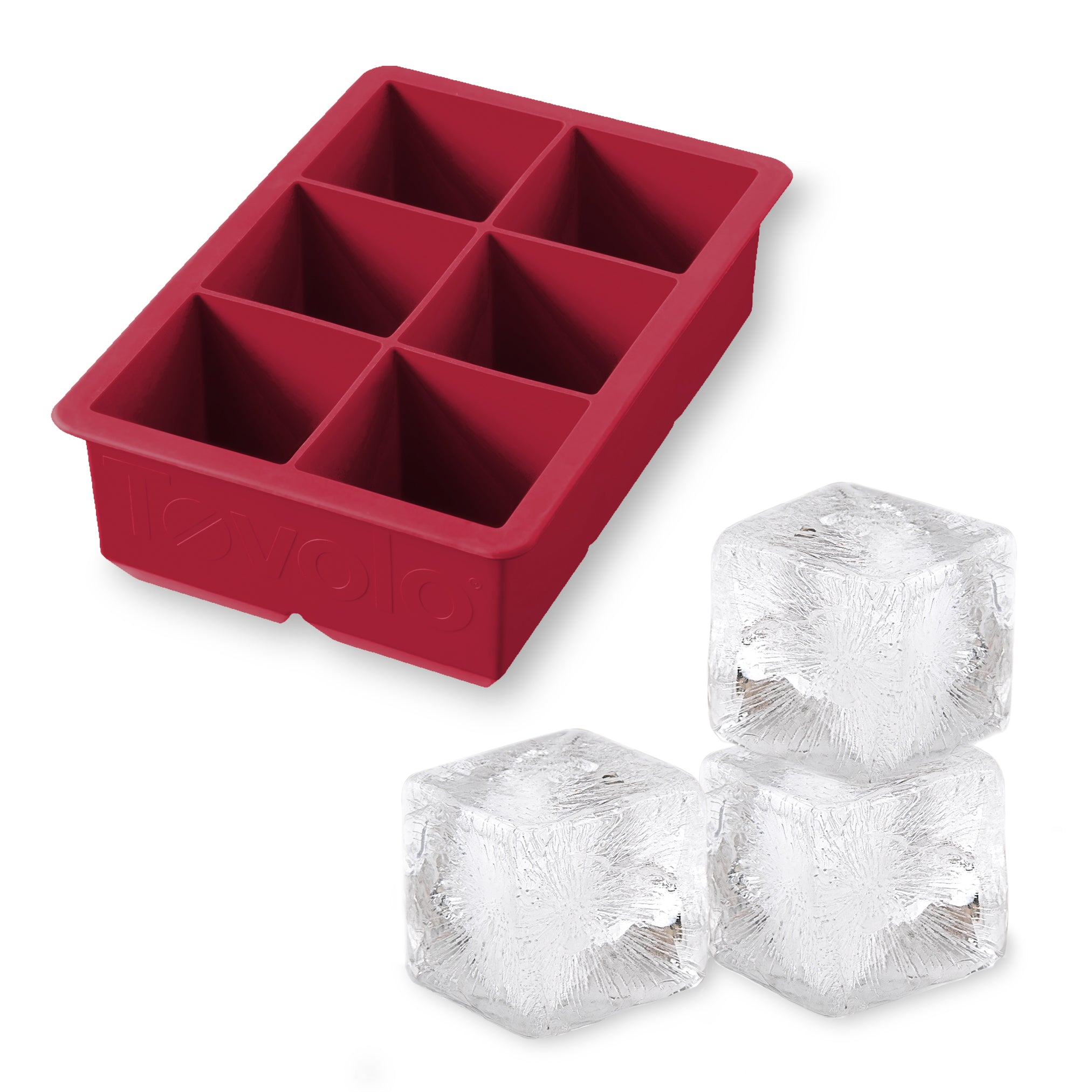 The tovolo King Cube Silicone Ice Mold features six large compartments and is shown with three clear craft ice cubes—ideal for creating impressive drinks with this durable, red ice cube tray.
