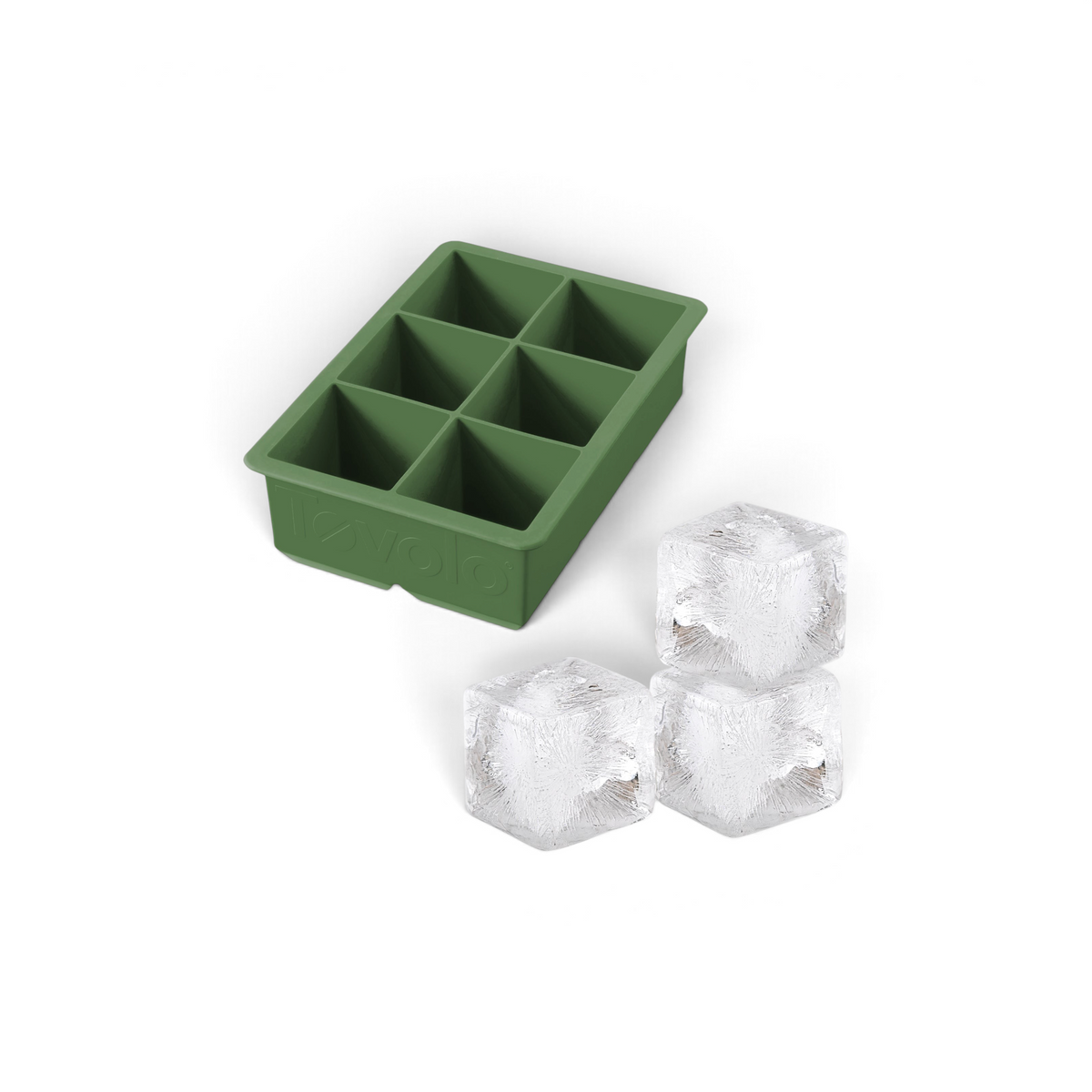 The tovolo King Cube Silicone Ice Mold in green, featuring six compartments, is pictured beside three large, clear ice cubes.