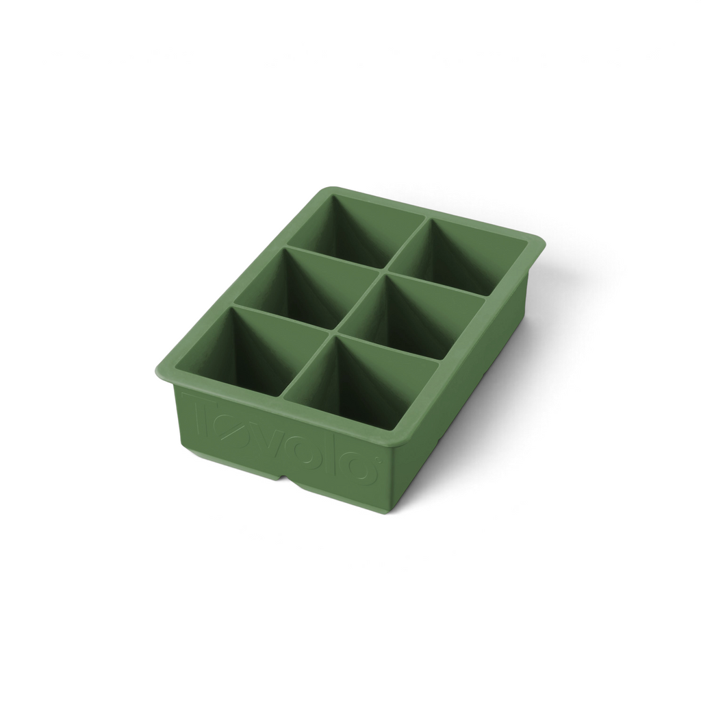 The tovolo King Cube Silicone Ice Mold is a green tray with six large square compartments, ideal for making big ice cubes. The brand name 'tovolo' is embossed on the side and visible from an angle.