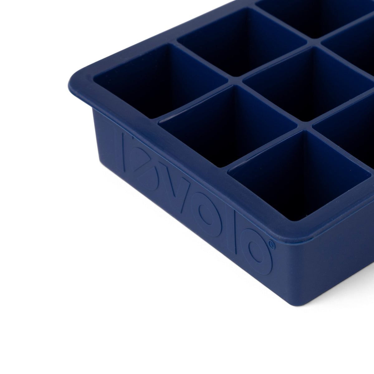 A close-up of tovolo Perfect Cube Silicone Ice Molds (Set of 2) in blue, featuring large square compartments and "evolog" embossed on the side, designed for durable, long-lasting ice.