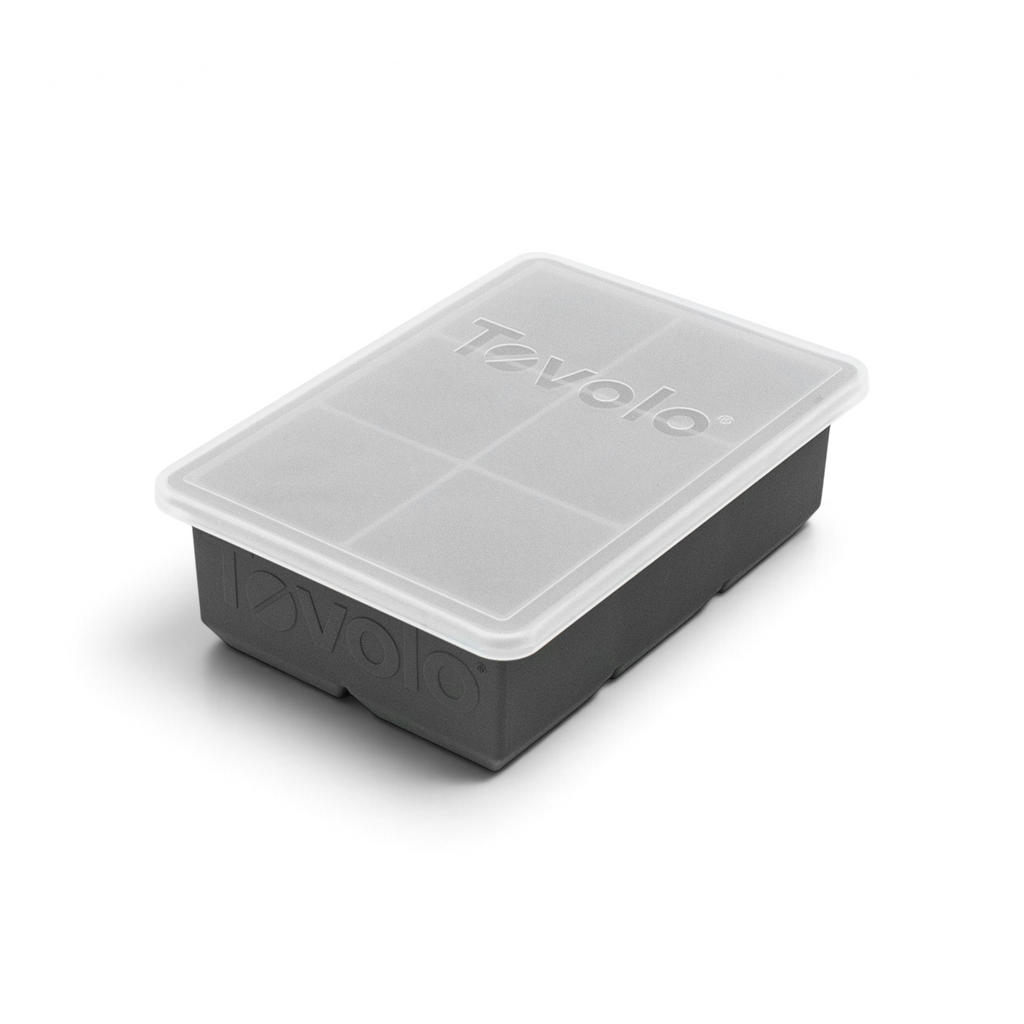 The tovolo King Cube Silicone Ice Mold is a gray, rectangular tray with a clear plastic lid. Both are labeled "tovolo" and designed to make large, perfectly square ice cubes.