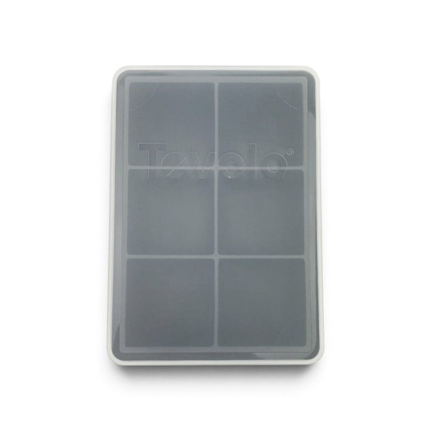 The tovolo King Cube Silicone Ice Mold is a gray rectangular tray with six large compartments for ice cubes, includes a clear plastic lid, and is pictured from above on a white background.