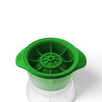 A green, round tovolo Baseball Ice Mold with side handles and a segmented wheel-like design sits atop a transparent container; comes as a set of 2.