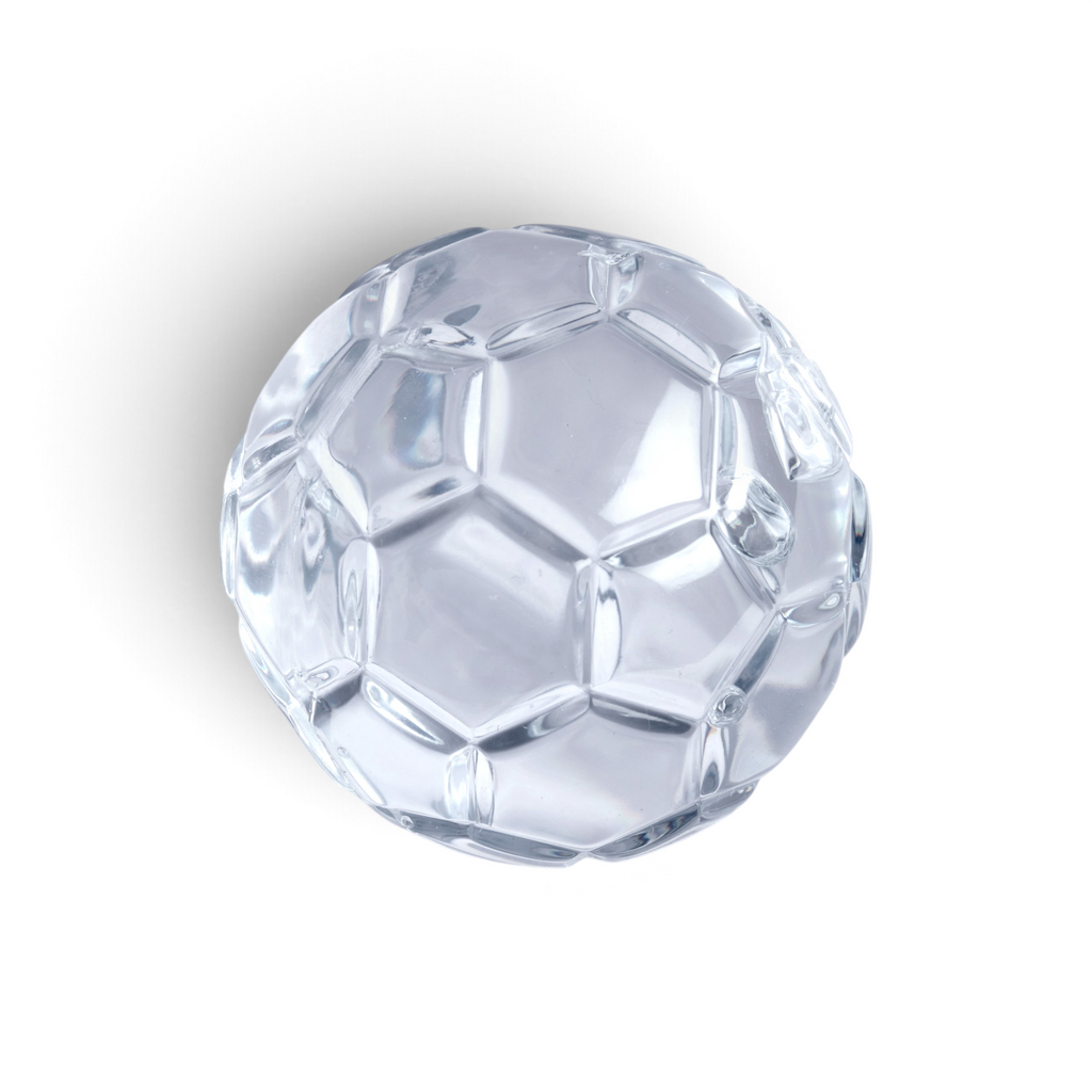A set of two clear, faceted glass-like baseball-shaped ice molds by tovolo, featuring classic stitched patterns and placed on a white background with a subtle shadow underneath.