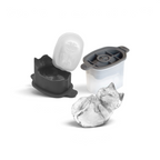 A tovolo Dog Ice Mold and its lid, shown open, with a detailed dog-shaped ice cube lying in front. Perfect for craft ice enthusiasts, the set of two molds forms a dog lying down with its paws together.