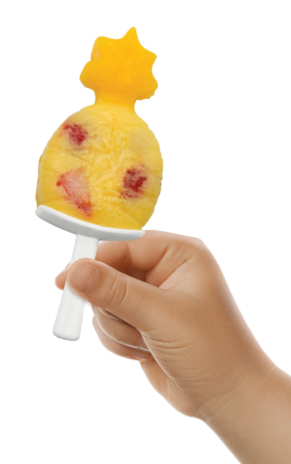 A child holds a pineapple-shaped popsicle with a yellow top and red fruit pieces, made using tovolo Stackable Pop Molds on a white plastic stick, against a white background.