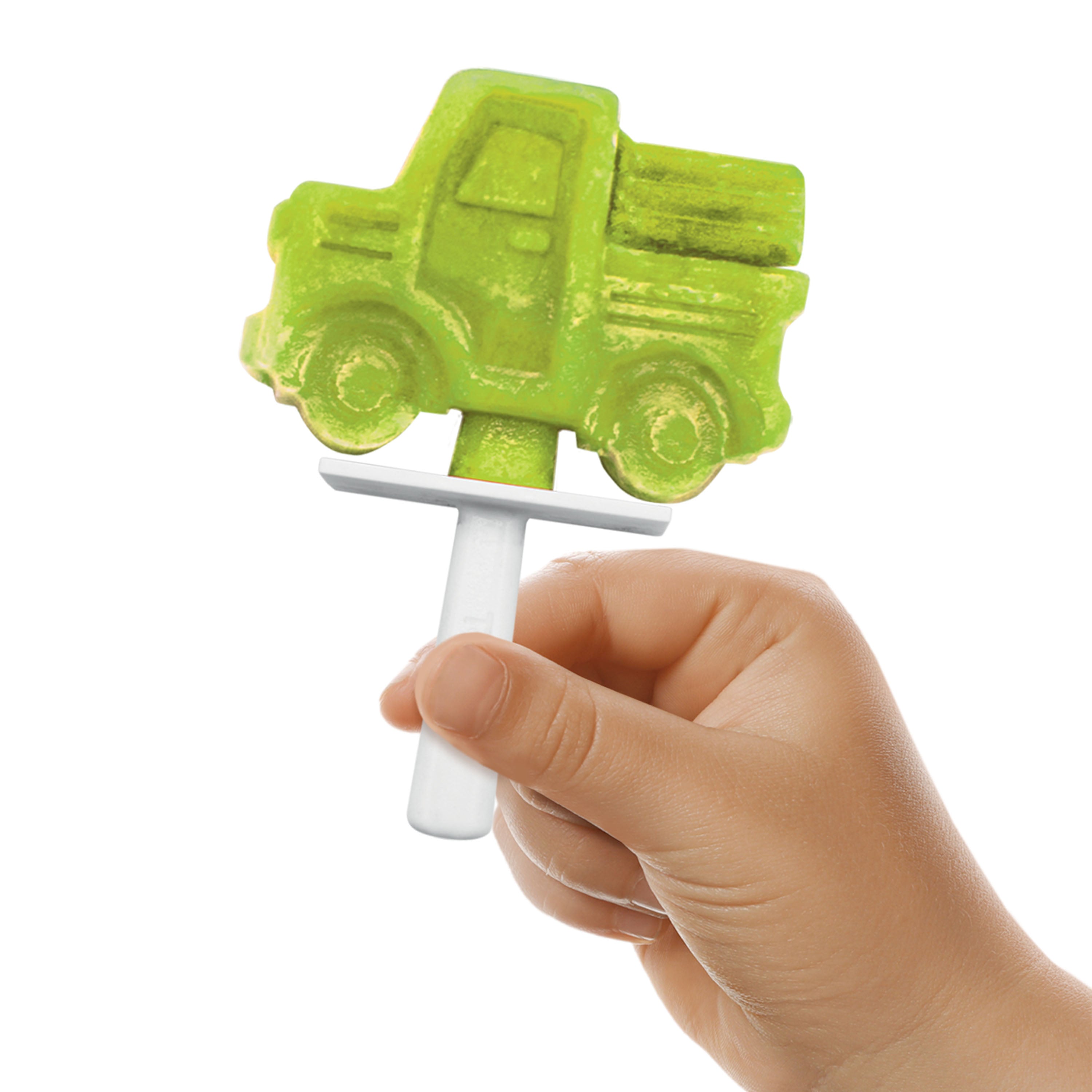 A hand holds a green popsicle shaped like a pickup truck, made with Stackable Pop Molds and a white plastic stick, against a plain white background.