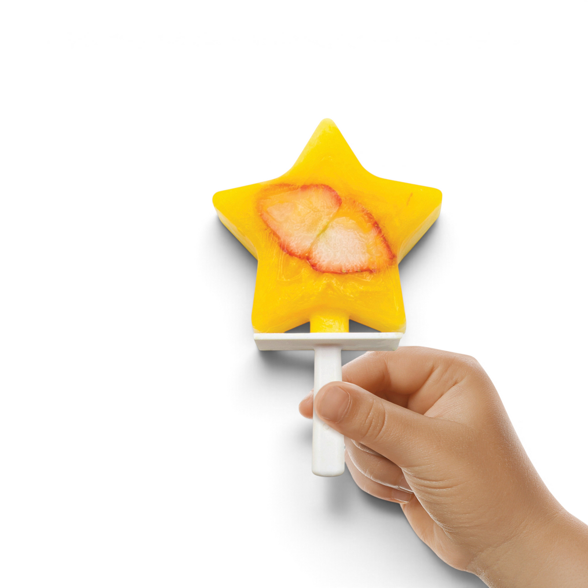 A hand holds a yellow star-shaped popsicle with visible strawberry slices, made using Stackable Pop Molds, against a white background.
