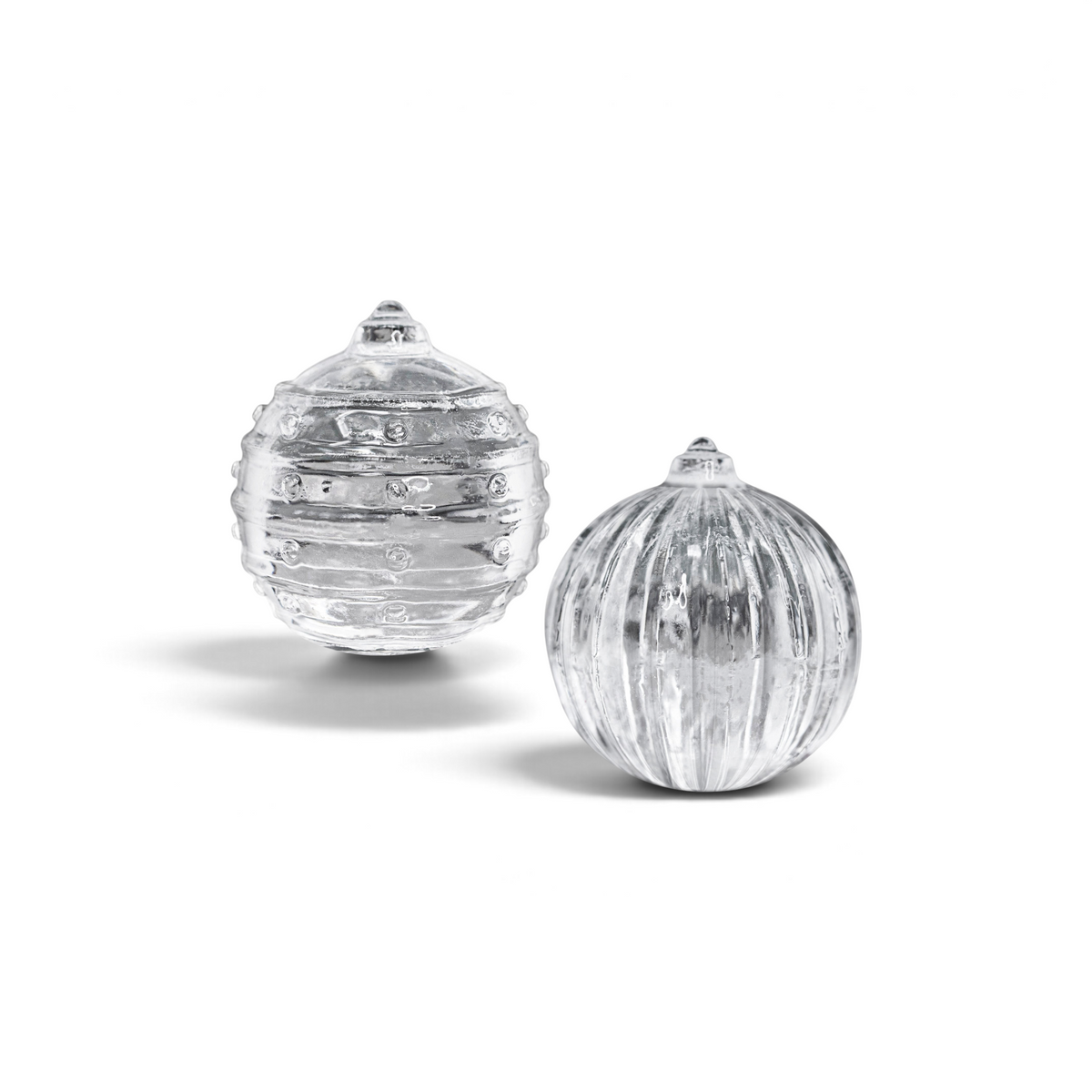 The tovolo Santa and Reindeer Ornament Ice Molds (Set of 2) feature textured clear glass designs with pointed tops—ideal for festive drinks or as a stylish Christmas gift.